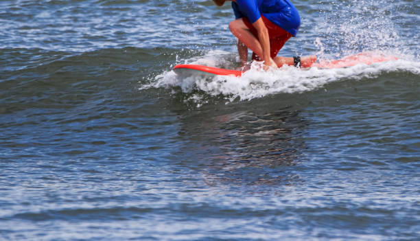 istock Man riding a surfboard on the top of a small wave 1574742761