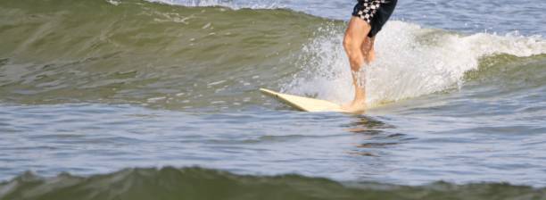 istock Surfer riding a small wave on his surfboard 1574742880