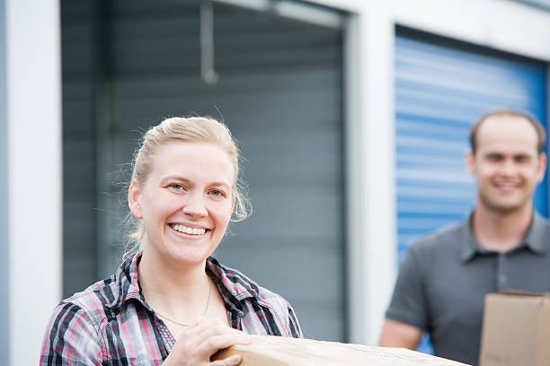 Man and Woman Holding Boxes at Self Storage Unit stock photo