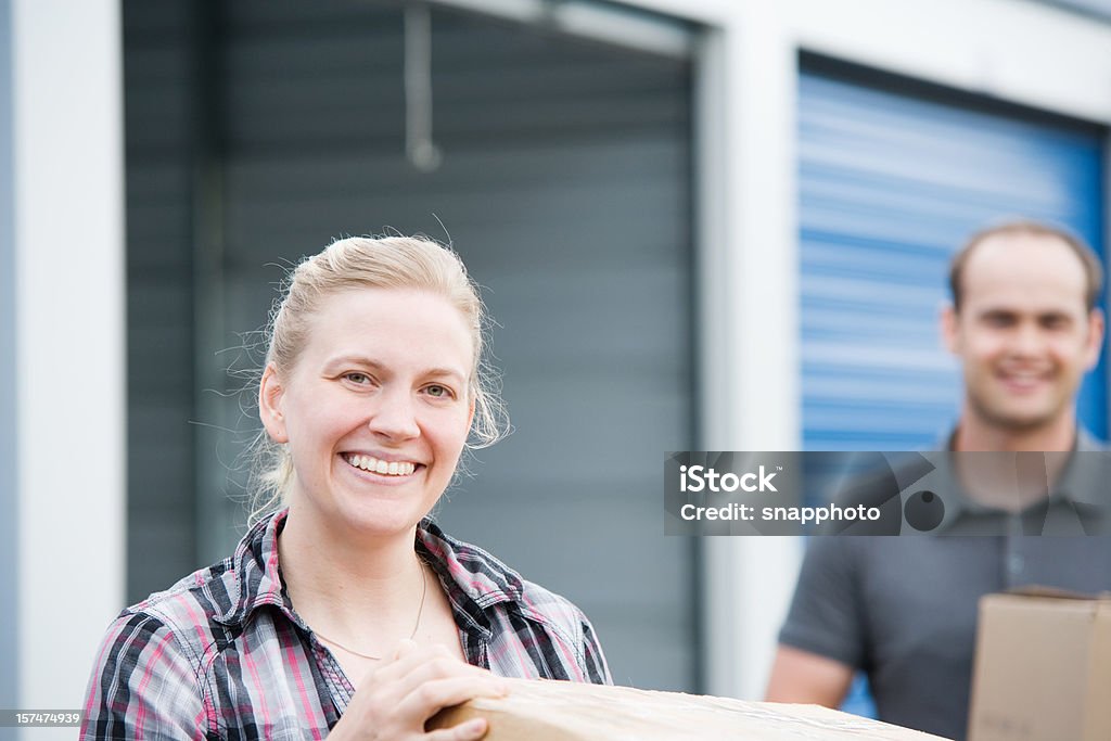 Homem e mulher segurando caixas de auto unidade de armazenagem - Foto de stock de Autoarmazenamento royalty-free