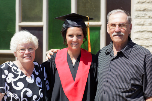 Female graduate posing with grandparents