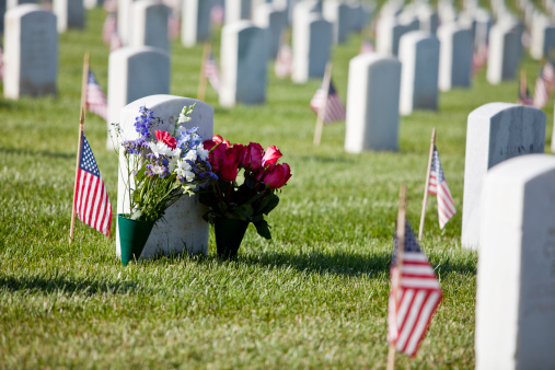 The flags on the headstones of soldiers in a cemetery on memorial day.
