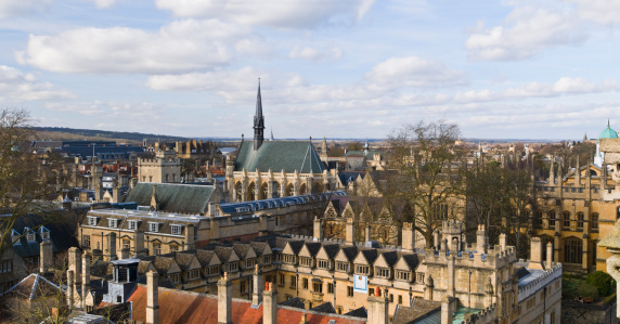 Aerial view of Oxford, England, flying over the city centre buildings and the colleges and libraries of the famous university on a cloudy day in winter.