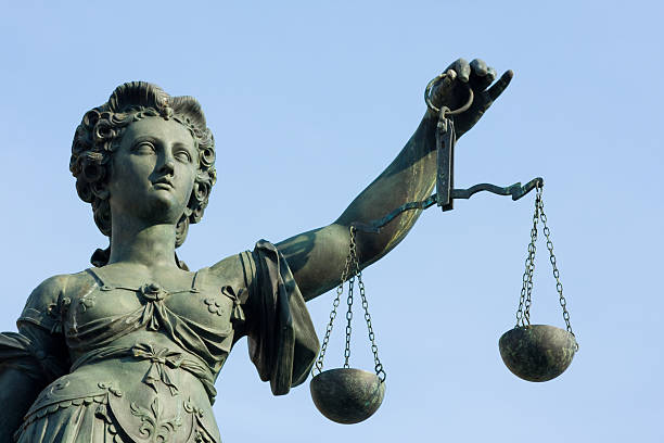 istock ancient Lady Justice statue half portrait against blue sky 157475530