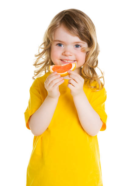 istock Little girl eating grapefruit 157475547