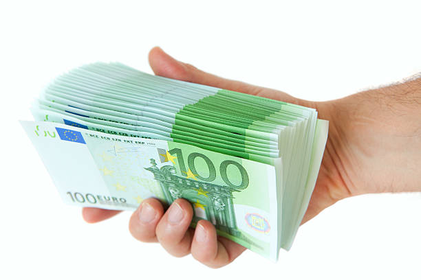 Closeup of an hand holding a stack of one hundred bills banknotes.