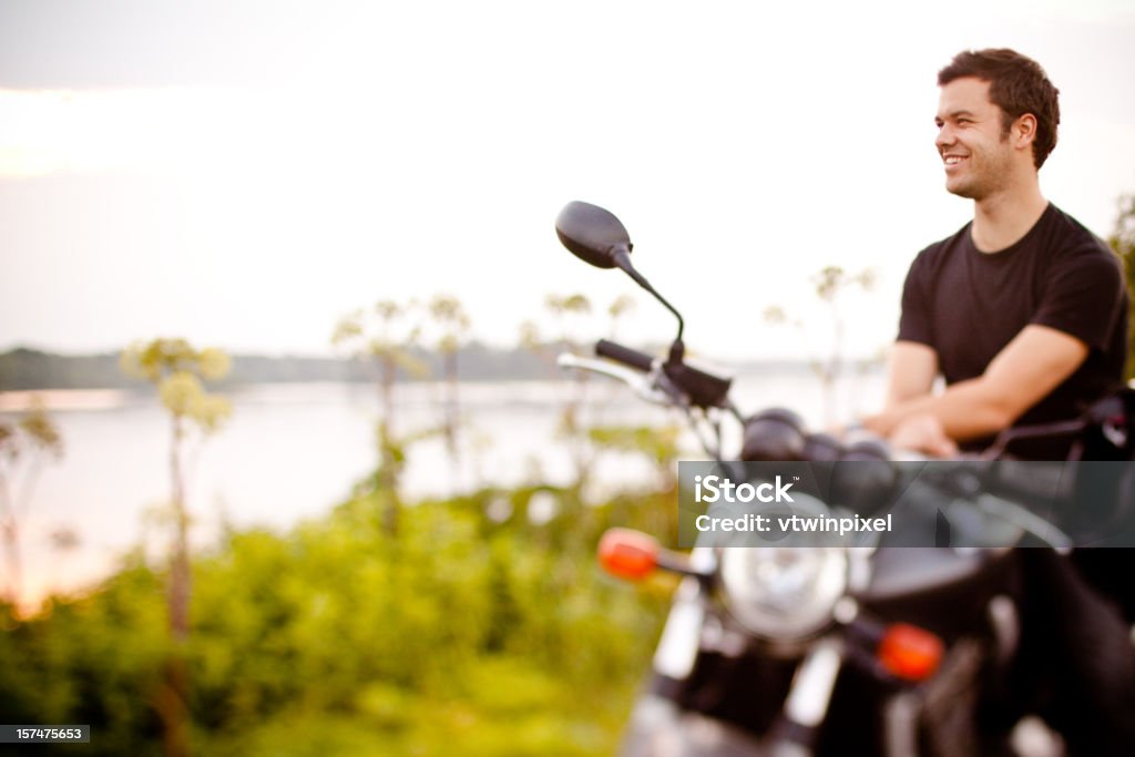 Souriant motard se détendre près de la rivière - Photo de Adulte libre de droits