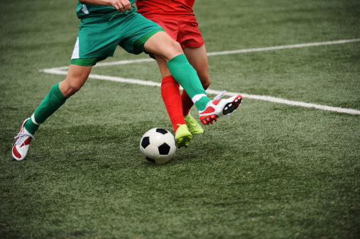 Close-up of two young soccer players duelling for the ball possesion