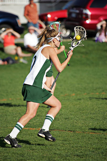 istock Female Lacrosse Player in Green and White Runs with Ball 157475751