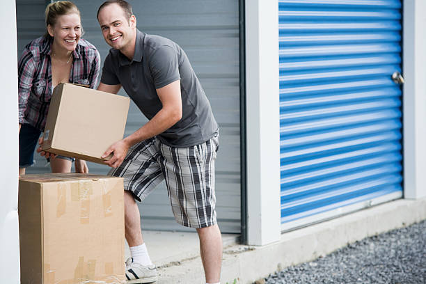 Man and Woman Moving Boxes at Self Storage Unit stock photo