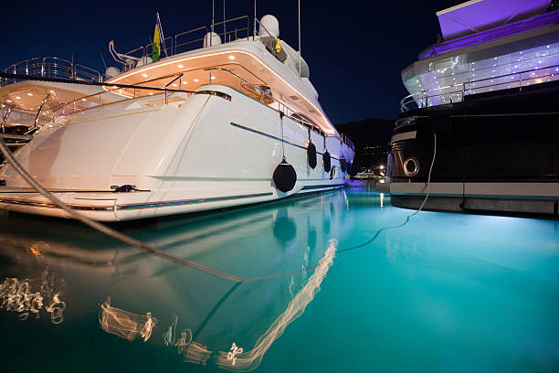 Big yachts in a marina at night.
