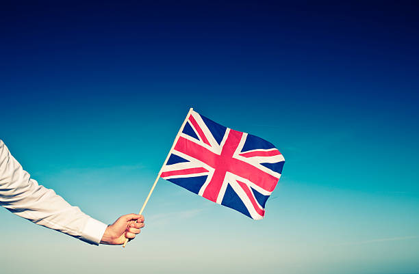 istock businessman's arm holding union jack flag 157475996