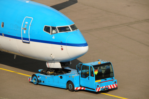 An airplane being towed to the runway for take-off.