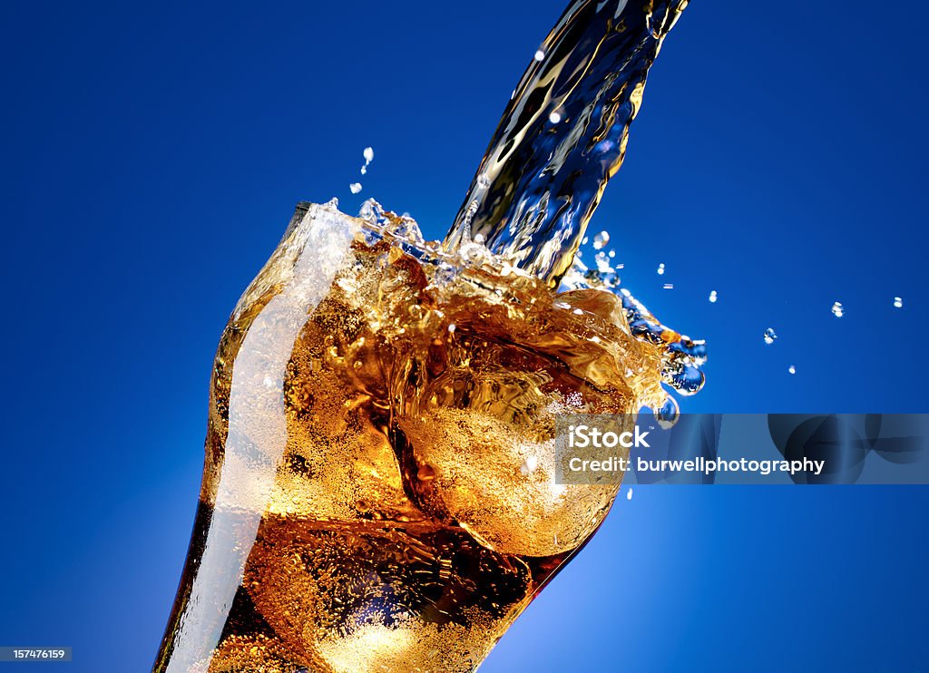 Cola avec splash, isolé sur le grand bleu - Photo de Soda libre de droits