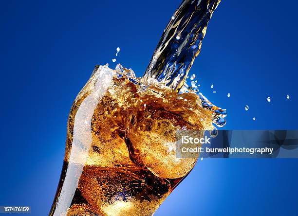 Cola With A Large Splash Isolated On Blue Stock Photo - Download Image Now - Soda, Cola, Drinking