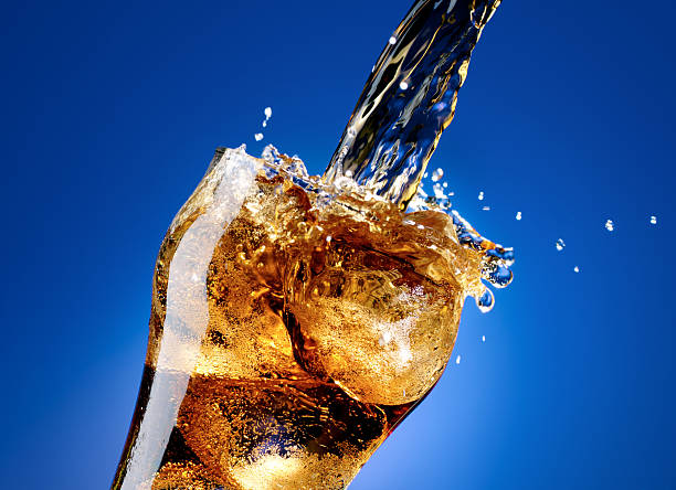 cola com um grande splash, isolado no azul - coke coca cola pouring ice imagens e fotografias de stock