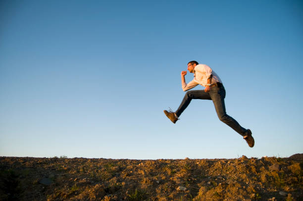 istock Man Leaping Across Desert Sands 157476238