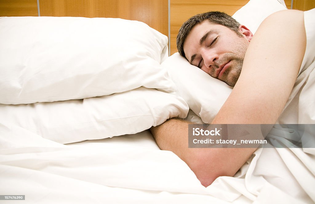 Mann schlafen im Hotel-Bett - Lizenzfrei Beistelltisch Stock-Foto