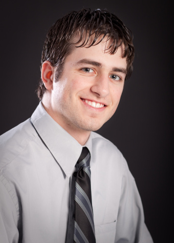 Head shot of an attractive young man wearing a dress shirt and tie.
