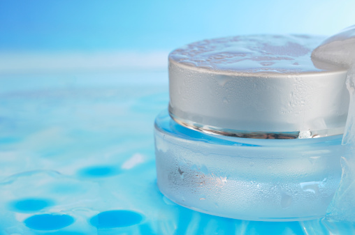 Moisturiser Jar in Ice Covered in Condensation against a blue background