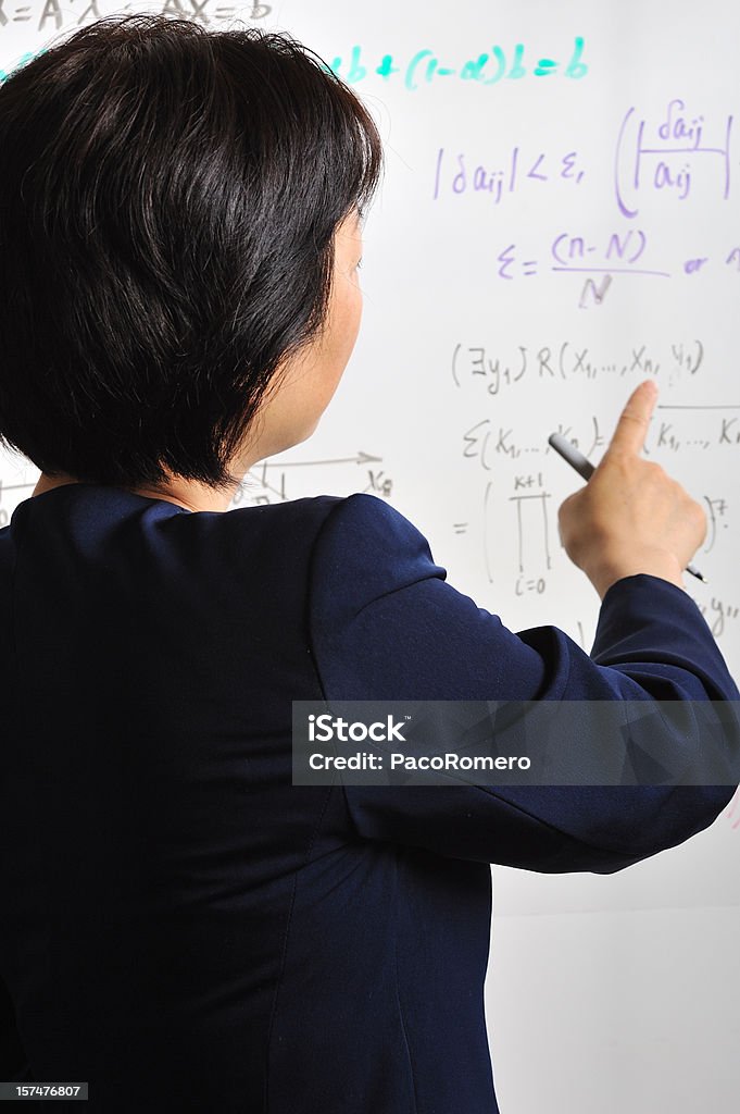 Mujer frente a una placa con fórmulas matemáticas - Foto de stock de 30-34 años libre de derechos