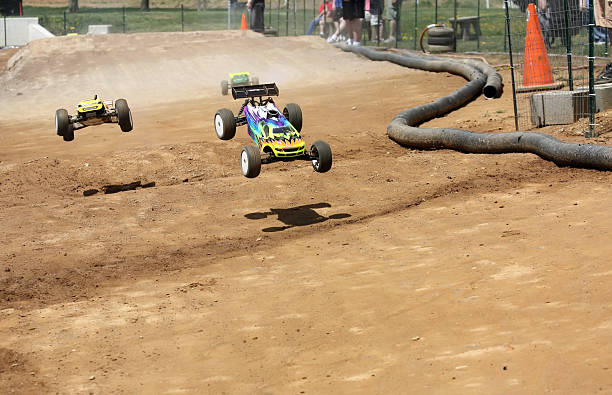 Radio Controlled Off-Road Car Racing Three radio controlled cars come flying down an off-road track in a race. Two are airborne.  toy vehicle stock pictures, royalty-free photos & images