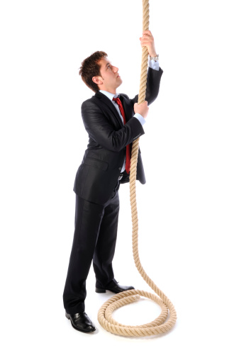 Businessman is pulling or climbing. Studio, isolated.