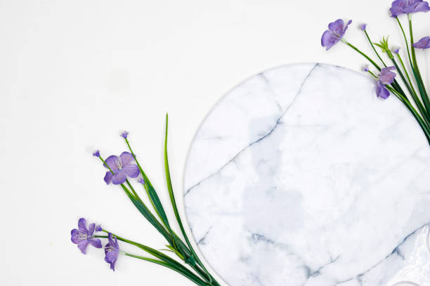 istock Empty marble board or podium with purple flowers 1574773697