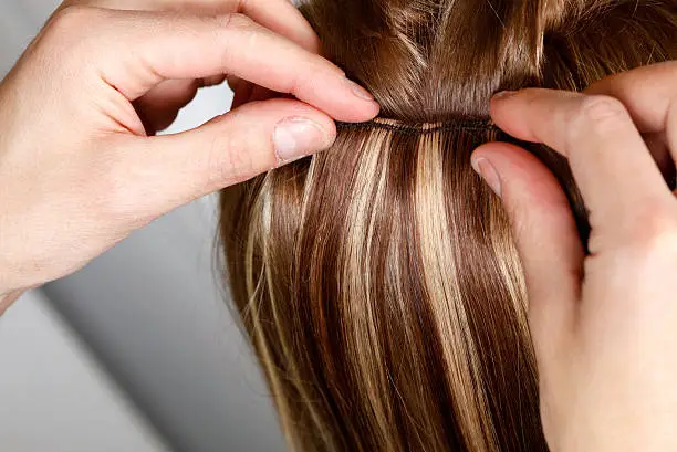 Photo of Hairstylist Applying Hair Extensions