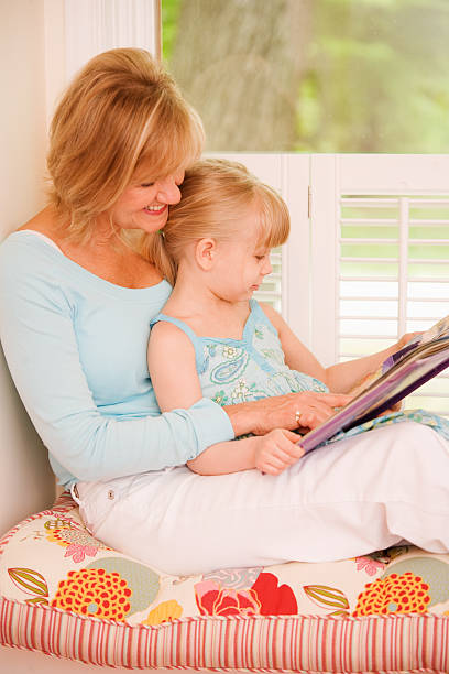 お子様と女性の読書に windowseat - girl reading ストックフォトと画像