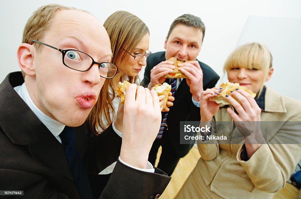 office workers eating Hungry office workers eating sandwich during lunch break 12 O'Clock Stock Photo