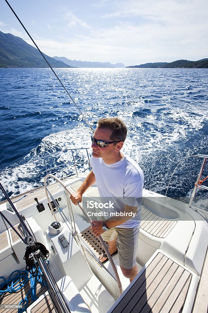 Счастливый skipper езда Парусная лодка - Стоковые фото Мужчины роялти-фри