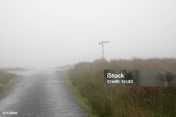 Signpost On Foggy Moorland Road Stock Photo - Download Image Now - Crossroad, Crossroads Sign, Spooky