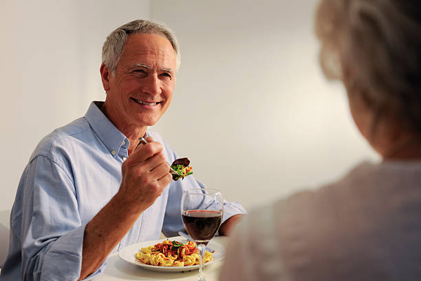 istock seniors eating evening meal 157478118