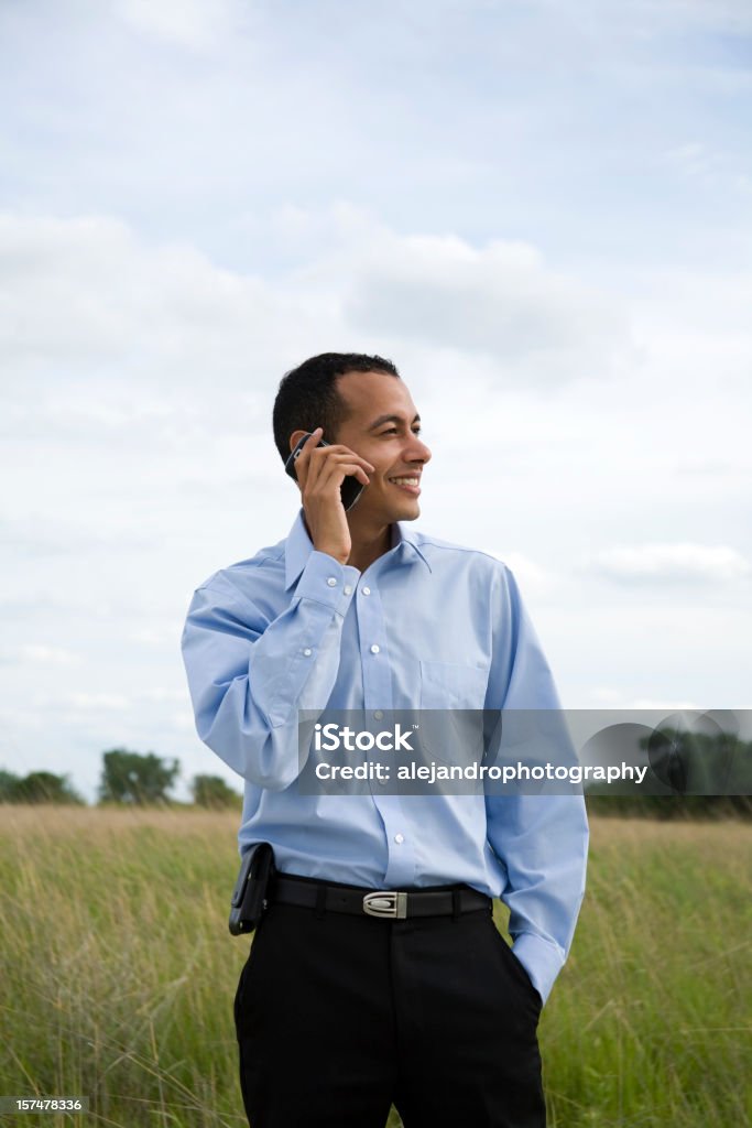 Latino-americano maschio sul cellulare - Foto stock royalty-free di Abbigliamento