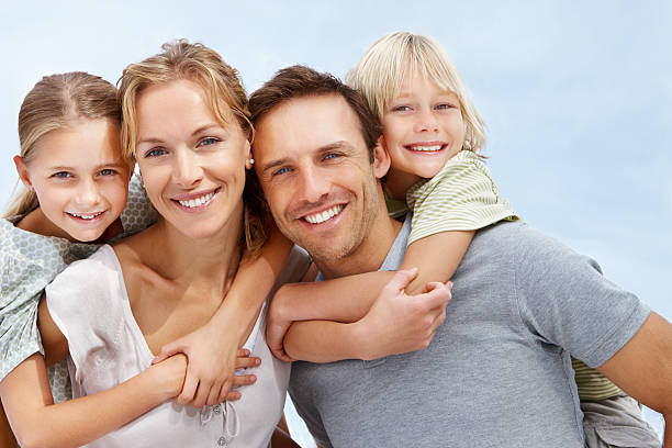felizes pais piggybacking os seus filhos - family white family with two children cheerful imagens e fotografias de stock