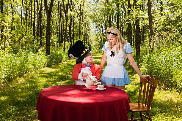 любознательным alice - bizarre hatter alice in wonderland tea party стоковые фото и изображения