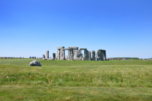 A wide shot showing the crowds (people unrecognisable as in the far distance) visiting Stonehenge. 