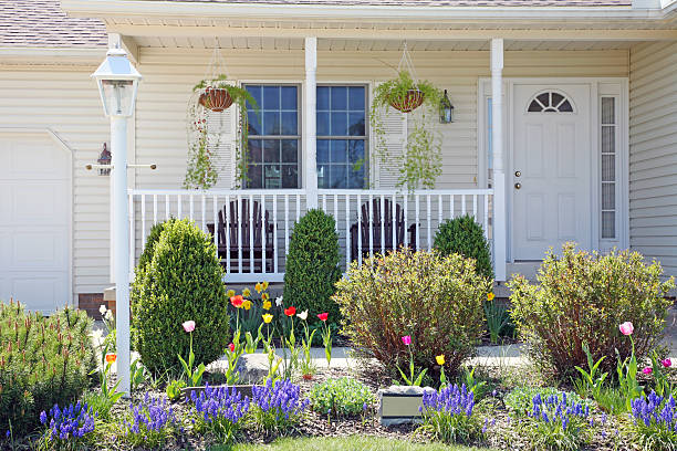 Pretty Home Facade With Spring Landscape Pretty vinyl clad ranch home with Amish made chairs on the porch, and lovely Spring landscaped yard. grape hyacinth photos stock pictures, royalty-free photos & images