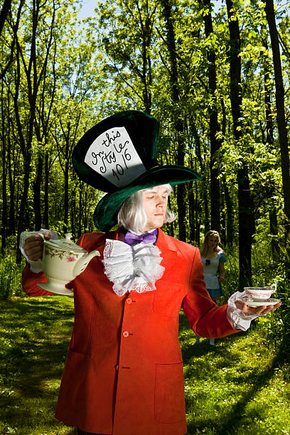 безумного шляпника» ожидают компании - bizarre hatter alice in wonderland tea party стоковые фото и изображения