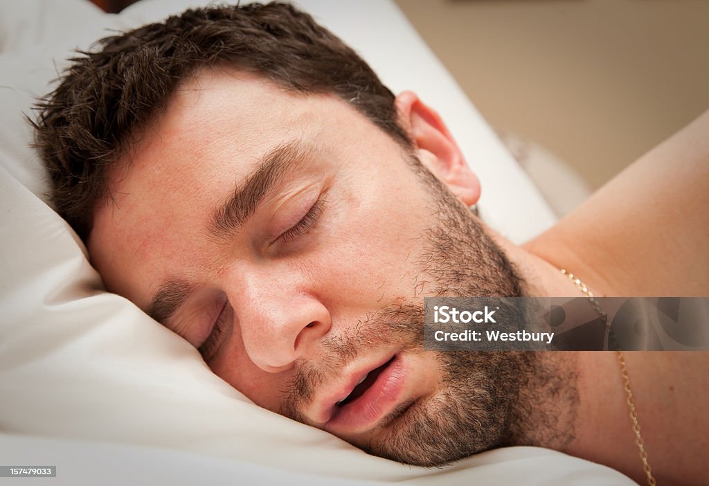 Close-up of young man with beard in sound sleep in bed Sleeping man Snoring Stock Photo