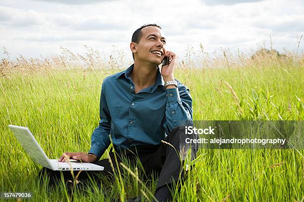 Latino Male On Laptop And Phone Stock Photo - Download Image Now - 20-29 Years, Adult, Adults Only