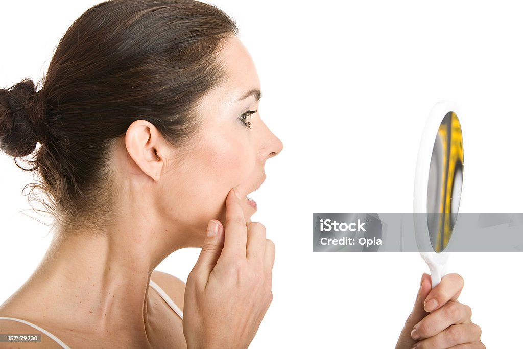 Femme contrôle la peau avec un miroir de maquillage - Photo de Femmes libre de droits