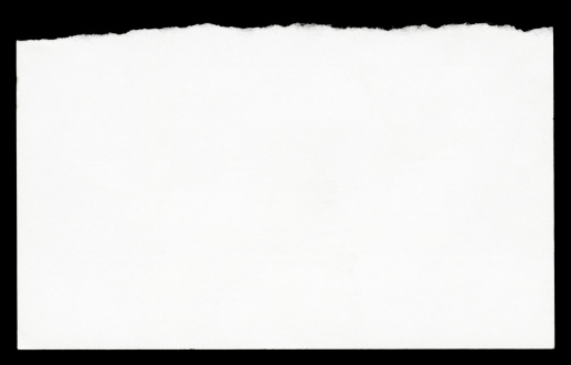 High resolution image of torn note paper isolated on black background.
