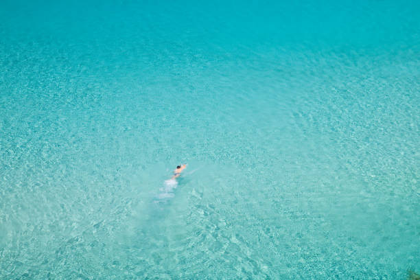 istock Man swimming alone in turquoise water 157479260