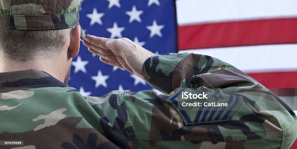 American Military Salute Against US Flag Air Force soldier saluting the American Flag. US Veteran's Day Stock Photo