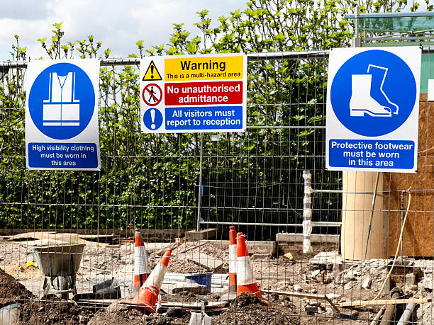 Construction site warning signs A variety of signs on a construction site fence. unsafe workplace stock pictures, royalty-free photos & images