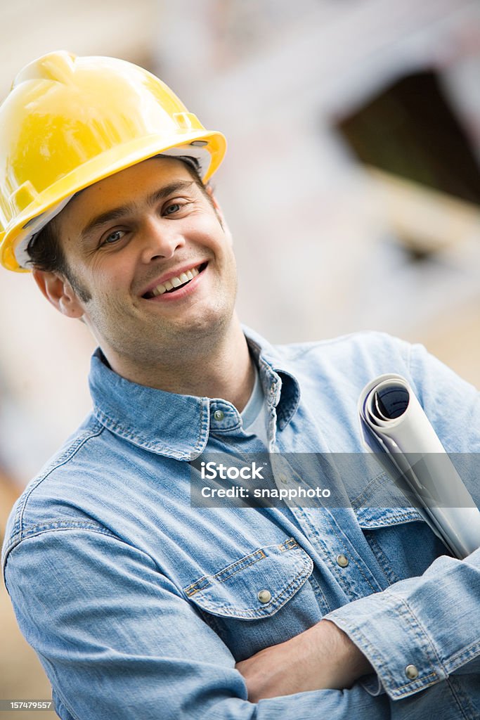 Homem a segurar projectos de construção usando Capacete de proteção - Royalty-free Adulto Foto de stock