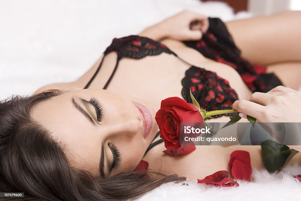 Bella donna sdraiata sul letto in Lingerie rosa con singola - Foto stock royalty-free di 16-17 anni
