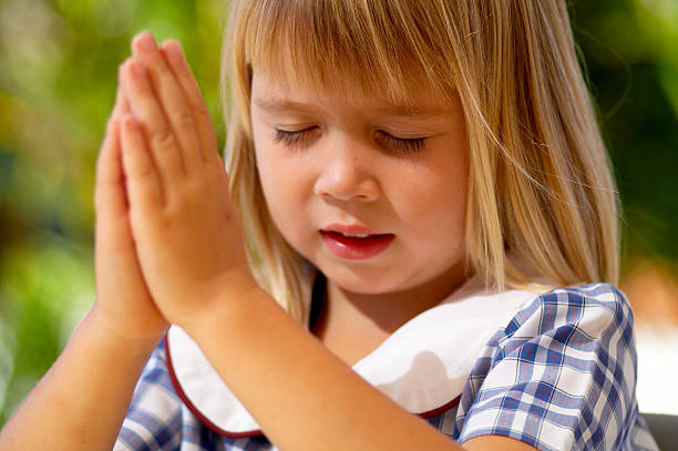 Little girl praying stock photo